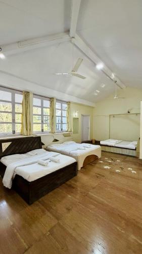 a large room with three beds in it at Niwas Villa in Vihur