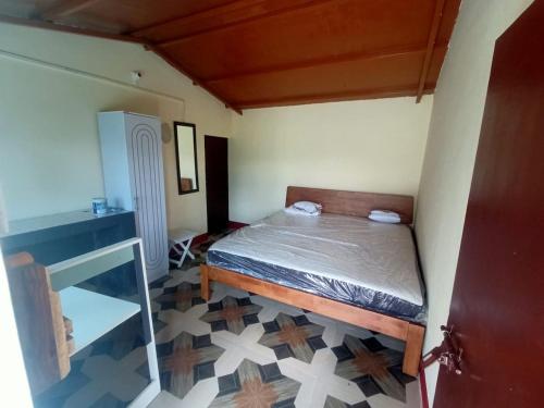 a small bedroom with a bed and a tiled floor at Almora Nainital-Kausani Highway Kosi Bazar in Almora