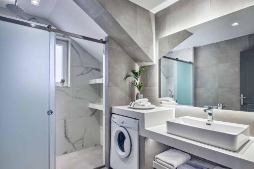 ein Badezimmer mit Waschbecken und Waschmaschine in der Unterkunft Ether Villa View in Lithakia
