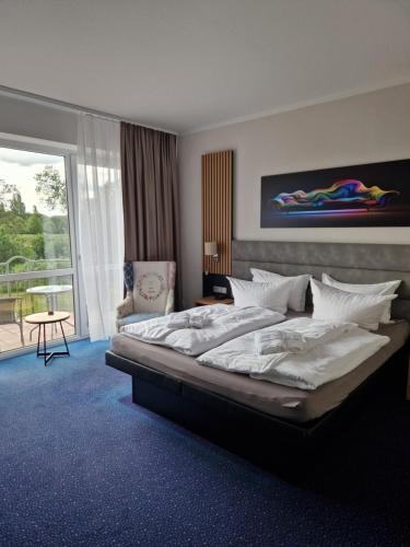 a bedroom with a large bed and a balcony at Turmhotel Schwedt in Schwedt