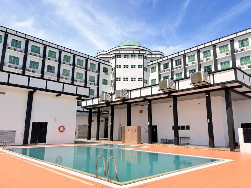 a hotel with a swimming pool in front of a building at Hotel Seri Malaysia Lawas in Lawas