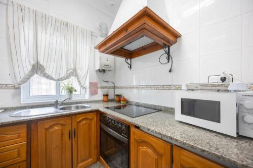 a kitchen with a sink and a microwave at En la Gloria in Barbate