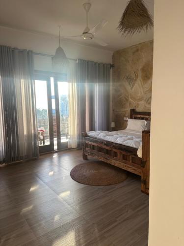 a bedroom with a bed and a large window at Lala salama Kendwa villas in Kendwa