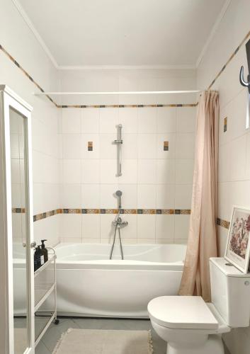 a white bathroom with a tub and a toilet at Villa Seashell in Prčanj