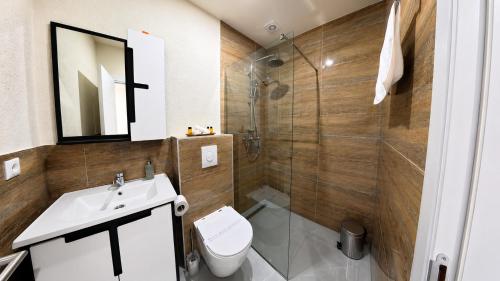 a bathroom with a toilet and a sink and a shower at Hotel Centar Sanski Most in Sanski most
