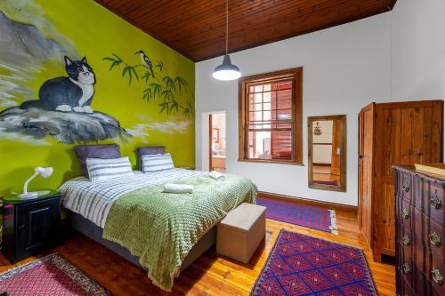 a bedroom with a cat painted on the wall at Emma's Place in De Rust