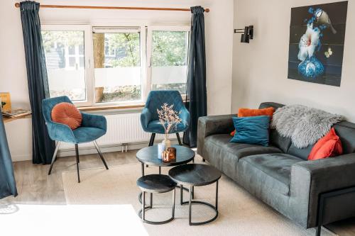 a living room with a couch and two chairs at Forrest Lodge in bosrijke omgeving de Veluwe - met terras, tuin en fietsschuurtje in Nunspeet