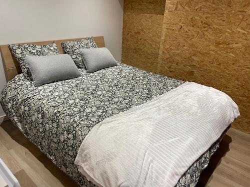 a bed with two pillows on it in a bedroom at Un écrin chic à deux pas de la mer in Merlimont