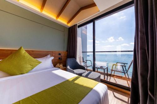 a hotel room with a bed and a large window at Triton Exotica in Maafushi