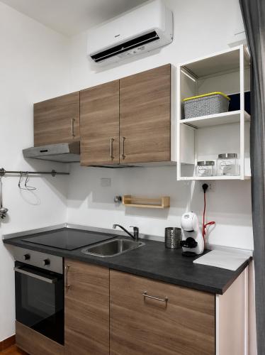 a kitchen with a sink and wooden cabinets at Casa Tropea Vibes in Tropea