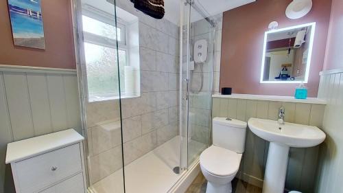 a bathroom with a shower and a toilet and a sink at F72 Chyreden, Riviere Towans in Hayle