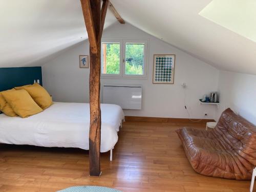 a bedroom with a bed and a chair in it at L'adret du bois in Sames