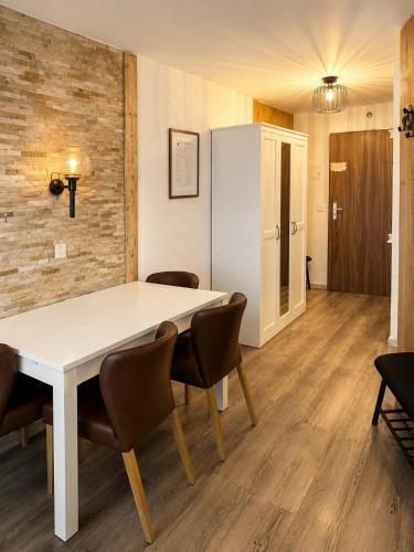 a dining room with a white table and chairs at Mountain Holiday Leukerbad Free Parking and WiFi Playroom 96 in Leukerbad