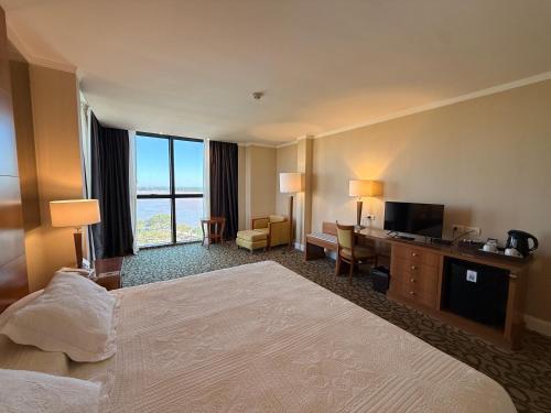 a hotel room with a large bed and a television at Turismo Hotel Casino in Corrientes
