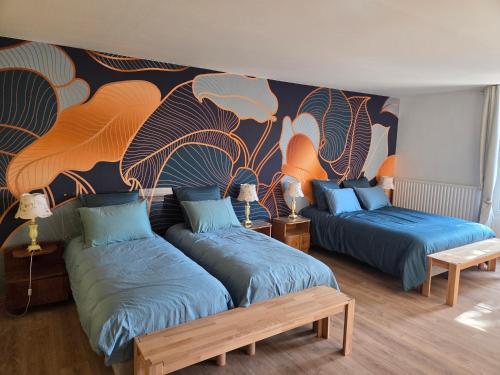 two beds in a room with a mural on the wall at La demeure de Chambord in La Ferté-Saint-Cyr