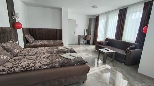 a living room with a bed and a couch at Къща за гости Орфей in Dospat