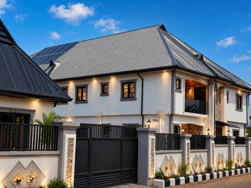 a white house with a black roof at Restnest suite in Benin City