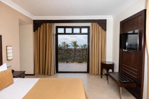 a hotel room with a bed and a large window at Oasis Beach & Spa - Blue Pearl in Saïdia