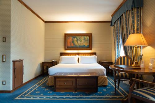 a hotel room with a bed and a table and chairs at Grand Hotel Trento in Trento