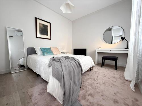 a white bedroom with a bed and a desk at Posadas de María Casa María 3 in Talavera de la Reina