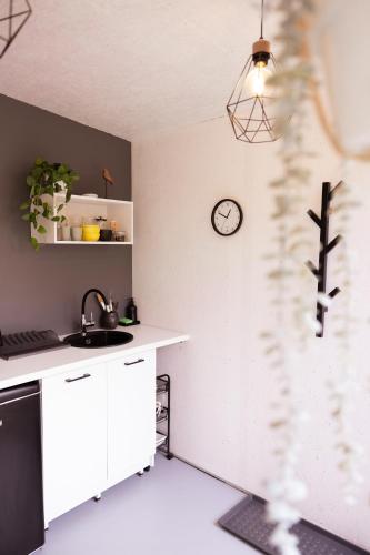 a kitchen with a sink and a clock on the wall at Liepaja Garden Studio with Terrace in Liepāja