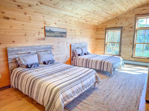 a bedroom with two beds in a log cabin at The Vines in Warren