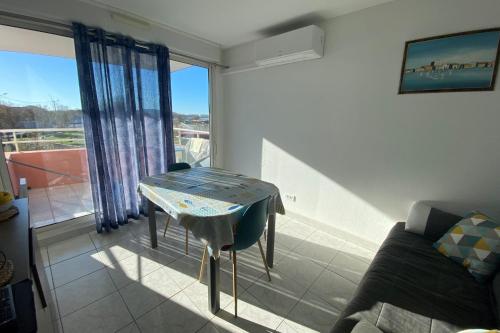 a living room with a table and a couch at comfort and breathtaking view in Frontignan