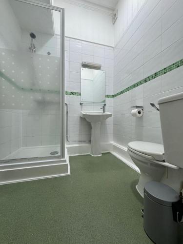 a bathroom with a shower and a toilet and a sink at Trivelles Belforte Hotel , Sale, Manchester - M33 2AE in Sale