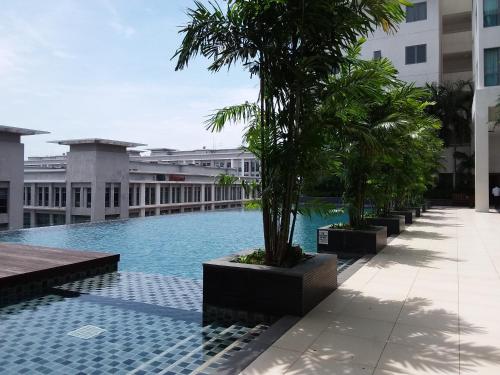 a swimming pool in the middle of a building with palm trees at Comfort Loft City Centre @ IMAGO Shopping Mall in Kota Kinabalu