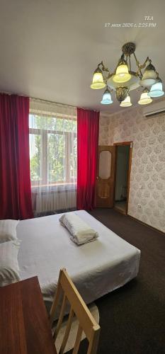 a bedroom with a large bed with red curtains at Corps Rose Velley in Almaty