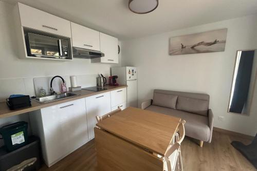 a small kitchen with a table and a couch at Hulot-838-Iodine parenthesis in Frontignan