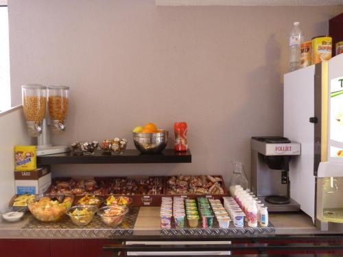 a kitchen with a counter with food on it at Hôtel et Appart 'hôtel Chez Gino ETAPLES-Le Touquet in Étaples