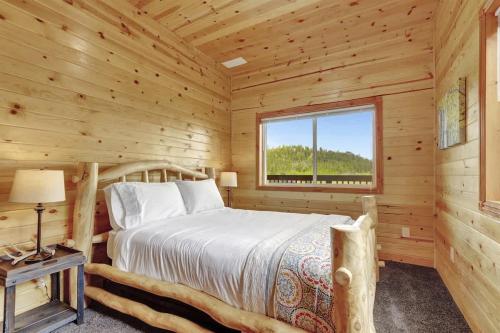 a log cabin bedroom with a bed and a window at Cozy Deer Valley Cabin- Views Fireplace & Deck in Jefferson