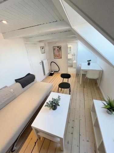 a living room with two tables and a couch at Bright and central city apartment near Aalborg Bus in Aalborg