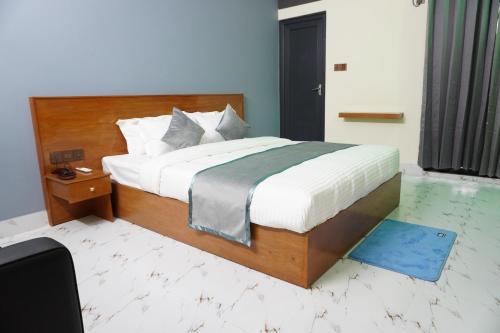 a bedroom with a large bed with a wooden headboard at Hotel Comfort Inn Sylhet in Sylhet