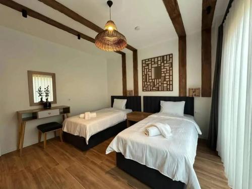 a bedroom with two beds and a chandelier at Quba in Quba