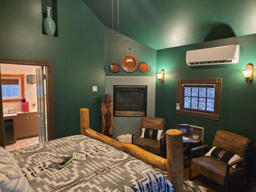 a bedroom with green walls and a bed and a fireplace at Rock Cottage Gardens B&B in Eureka Springs
