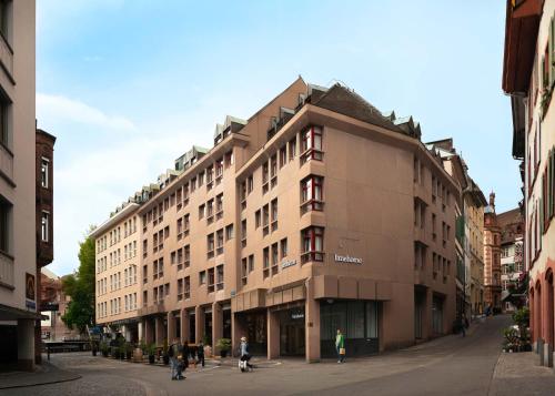 a large building on a street in a city at Limehome Basel Town Hall in Basel
