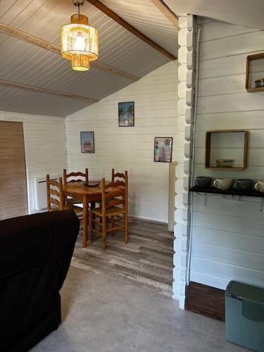 a dining room with a table and chairs and a chandelier at Chalet à Biscarrosse in Biscarrosse