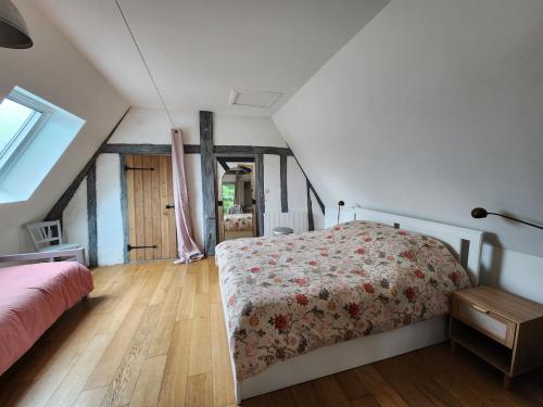 a bedroom with a bed with a floral bedspread at Charming cottage in Boursay