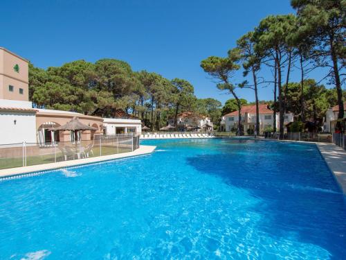 a large swimming pool with blue water at Del Pinar Apart in Costa del Este
