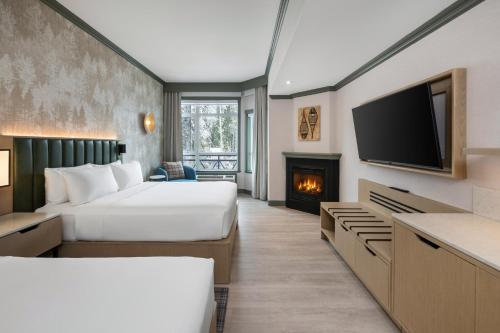 a hotel room with two beds and a fireplace at Royal Canadian Lodge in Banff