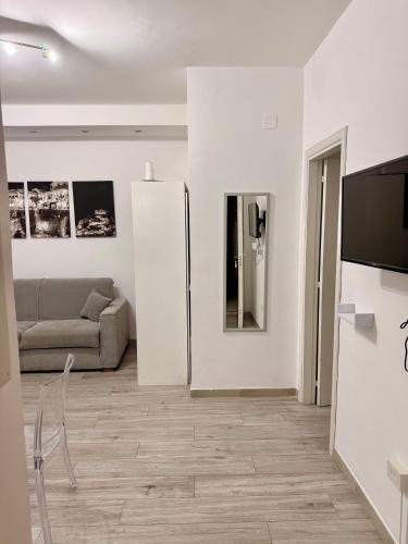 a white living room with a couch and a refrigerator at Casa Valentina in Tropea