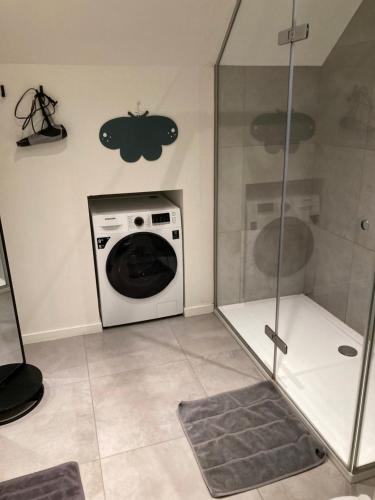 a laundry room with a washing machine and a shower at Christina in Nieuwpoort