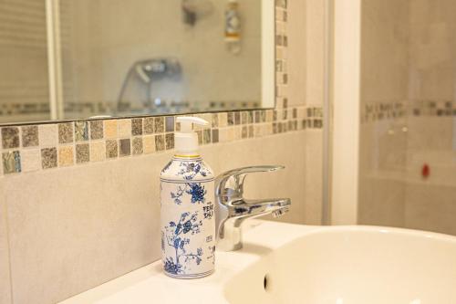 a blue and white bottle of soap sitting on a sink at Albergo La Veranda in Tavarone