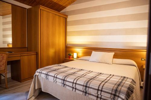 a small bedroom with a bed and a desk at Albergo La Veranda in Tavarone
