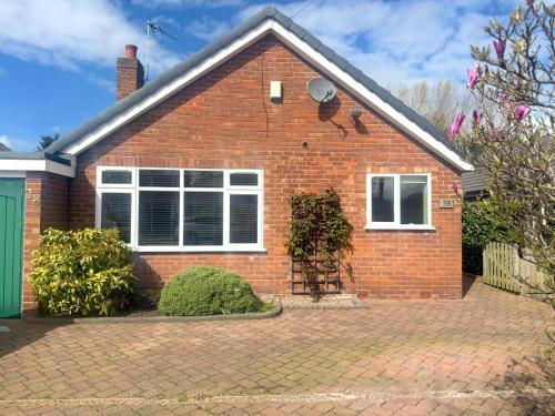 a red brick house with a brick driveway at Greenfields Apartment in Chester