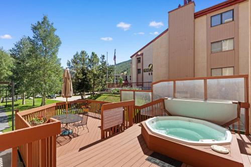 a hot tub on a deck next to a building at Summit House East #313 in Copper Mountain