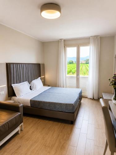 a bedroom with a bed and a large window at Hotel Residence Vallecorsa in Vada