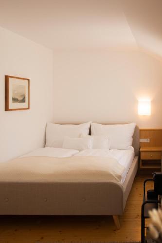 a bed with white sheets and pillows in a room at Casa Firmenich in Eckberg